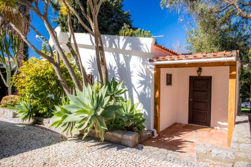a small white building with a brown door at Casa da Montanha in Luz