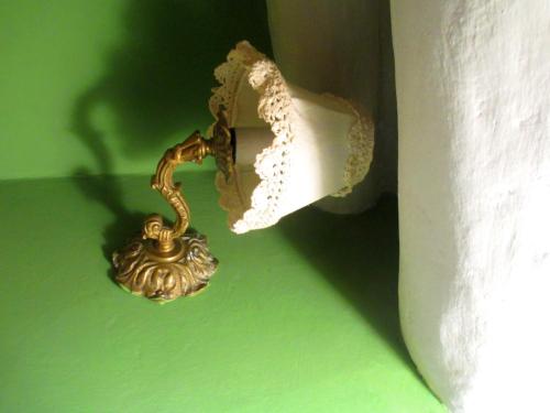 a brass toilet paper dispenser on a green wall at Quinua Boutique Apartments in Cusco