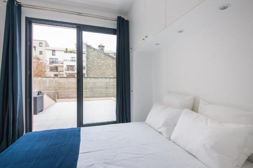 une chambre avec un lit et une grande fenêtre dans l'établissement Le Scandinave, F3 avec terrasse, Villa Saint Charles, à Paris