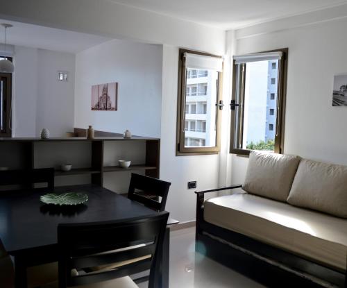 a living room with a table and a couch at XV Apartamentos in La Plata