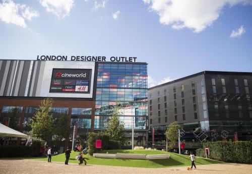 a group of people walking in front of a building at London - Wembley International Hotel in London