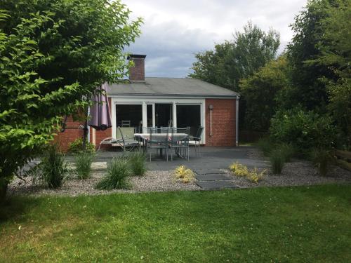 a patio with a table and chairs in a yard at Gemütlicher Bungalow in Neuharlingersiel