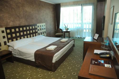 Ένα ή περισσότερα κρεβάτια σε δωμάτιο στο Park Hotel Izida