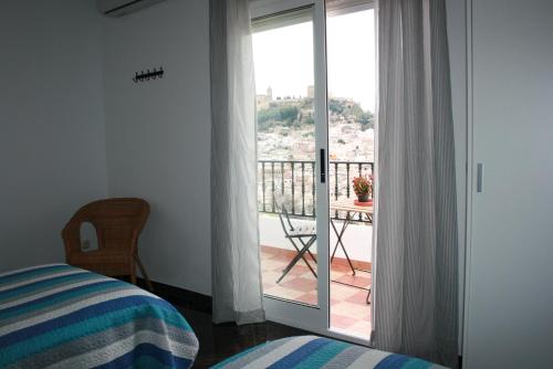 a bedroom with a glass door leading to a balcony at Mirador Tierra de Frontera in Alcalá la Real