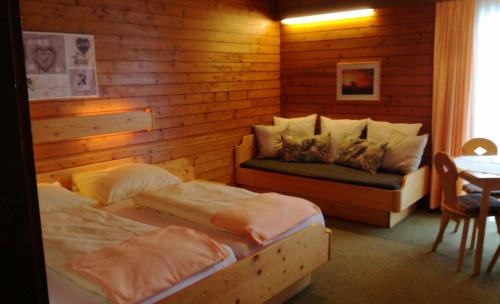 Sankt Stefan im LavanttalにあるHotel Garni Gästehaus Karinのベッドルーム1室(ベッド2台、ソファ付)