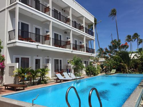 a hotel with a swimming pool in front of a building at MAY Bungalow in Mui Ne