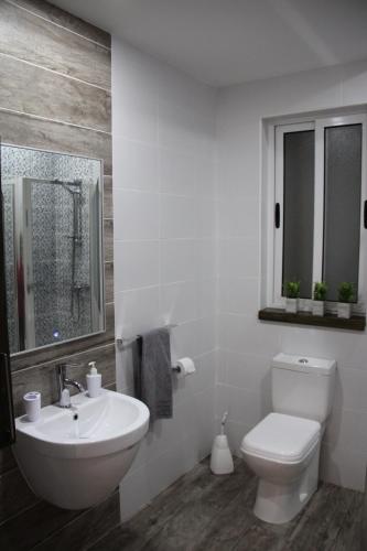 a bathroom with a white toilet and a sink at Marsascala Interlace Apartment with free parking in Marsaskala