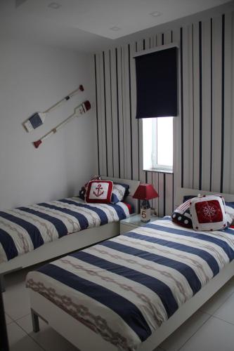 two beds sitting next to each other in a bedroom at Marsascala Interlace Apartment with free parking in Marsaskala