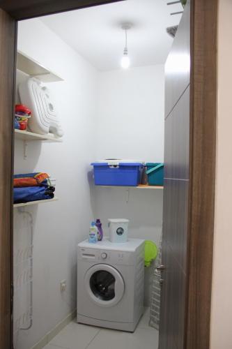 a bathroom with a washing machine in a room at Marsascala Interlace Apartment with free parking in Marsaskala