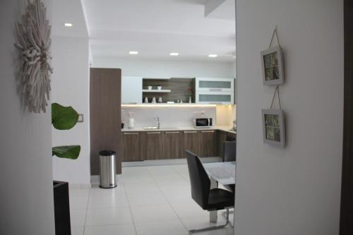 a kitchen with a table and a chair in a room at Interlace Apartment with free parking in Marsaskala