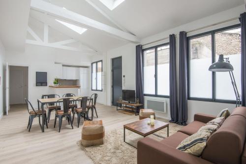un salon avec un canapé et une table dans l'établissement L'Industriel, loft de 2 chambres, Villa Saint Charles, à Paris