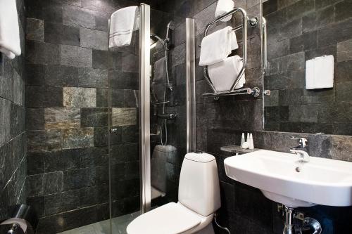 a bathroom with a toilet and a sink and a shower at Hotel Hellsten in Stockholm