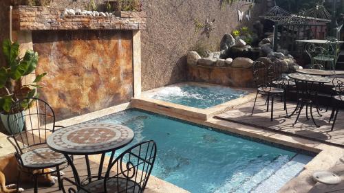 a pool with chairs and a table and a table and chairs at One32 Guesthouse Paradise in Kingston
