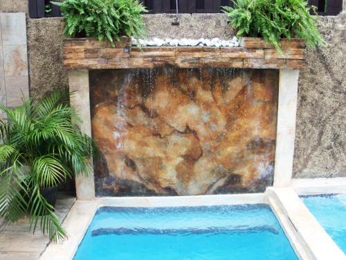 a swimming pool in front of a stone wall at One32 Guesthouse Paradise in Kingston