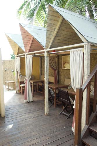 a wooden deck with wooden tables and curtains at One32 Guesthouse Paradise in Kingston