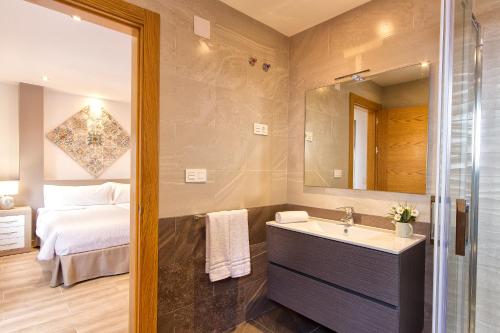 a bathroom with a sink and a bed and a mirror at Lucero 12 in Marbella