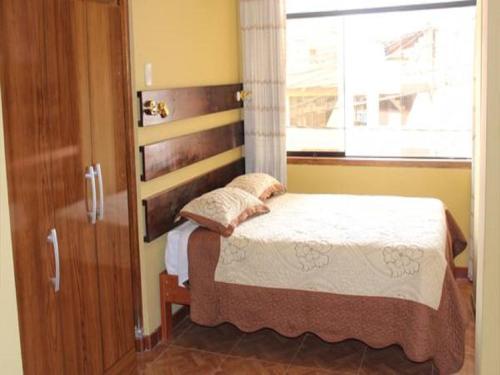a bedroom with a bed and a window at Kennedy Guest House in Cusco