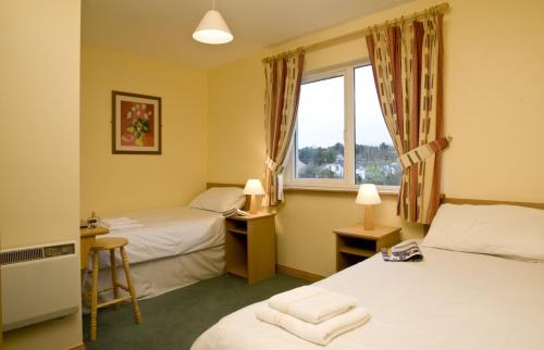 a hotel room with two beds and a window at Forest Haven Holiday Homes in Dunmore East