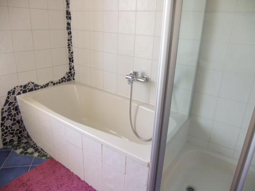 a bath tub with a shower in a bathroom at Siggis Home in Wilhermsdorf