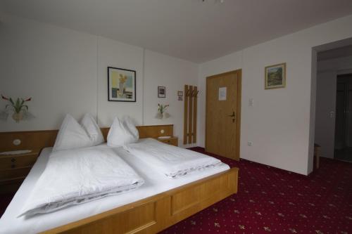 1 dormitorio con 1 cama grande con sábanas blancas en Gästehaus Walch-Riml, en Imst