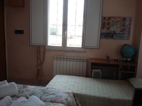 una camera con 2 letti, una scrivania e una finestra di Monolocale Monteverde a Roma