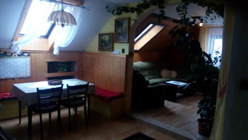 ein Wohnzimmer mit einem Tisch und einem Sofa in der Unterkunft U Tří Koček in Jablonné v Podještědí