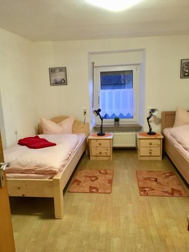 a bedroom with two beds and a window at Landhaus Düngenheim in Düngenheim