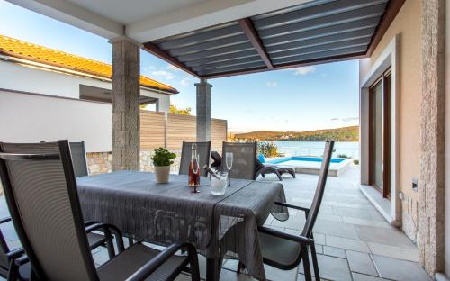 a table and chairs on the patio of a house at Villa Ema in Čižići