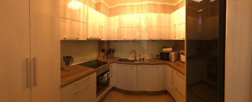 a kitchen with white cabinets and a black refrigerator at Vigo Luxe Apartment in Nesebar