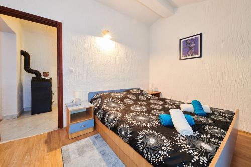 a bedroom with a bed with blue pillows at Apartman Nena in Čepljani