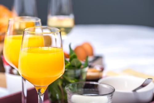 two glasses of orange juice sitting on a table at Hotel Sleep-Inn Box 5 in Nijmegen