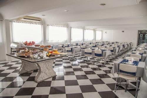 een grote kamer met een geruite vloer en een lange tafel en stoelen bij Atlantico Inn Apart Hotel in Santos