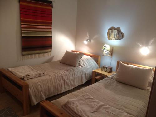 una camera con due letti e un tavolo con una lampada di Ruoktu a Saariselka