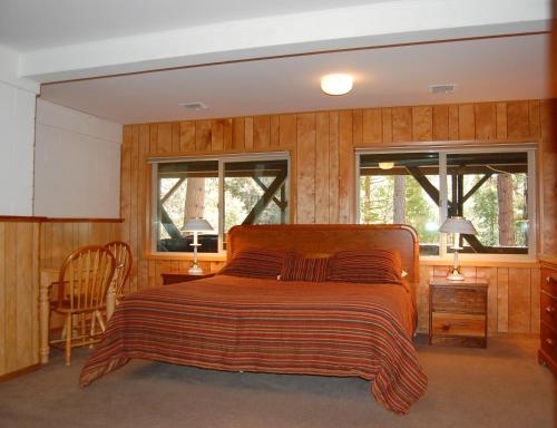 a bedroom with a bed and two windows at 99 Yosemite Mountain Lodge in Wawona