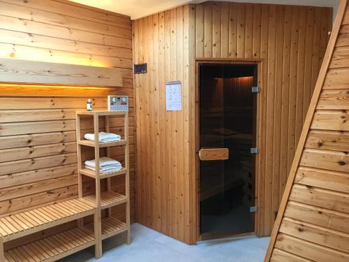 een sauna met houten lambrisering en een deur bij Appartement Brouwer in Egmond aan Zee