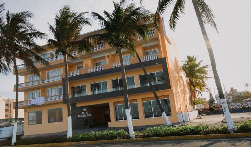 a building with palm trees in front of it at Hotel Real del Mar in Veracruz