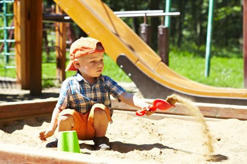 Un ragazzino che gioca nella sabbia in un parco giochi di Aparthotel Voglergasse a Baden-Baden