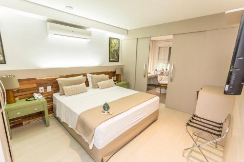 a bedroom with a bed and a television in it at Hotel Pousada do Bosque in Ponta Porã