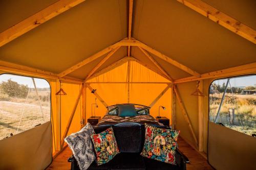 a bed in a tent with two windows at Appleby House & Rabbit Island Huts in Mapua