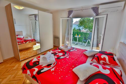 sypialnia z dużym łóżkiem z czerwonym i białym kocem w obiekcie Luxury apartment M&N in Split w Splicie