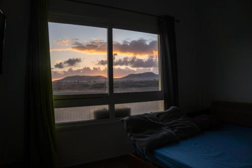 コティージョにあるApartamento luminoso a 200m de lagos de cotilloの夕日を望むベッドルームの窓