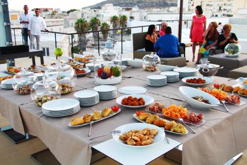 a long table with plates of food on it at Resort Il Mulino in Favignana