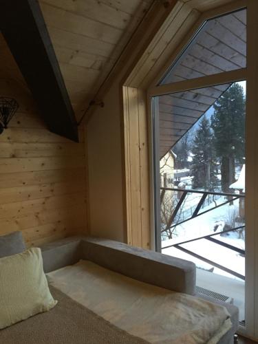 a bed in a room with a large window at Girske Povitria 2 in Yaremche