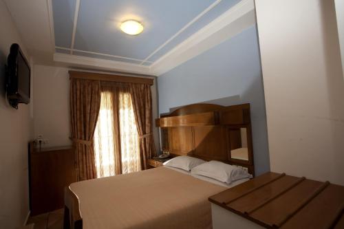 a small bedroom with a bed and a window at Hotel Katerina in Athens