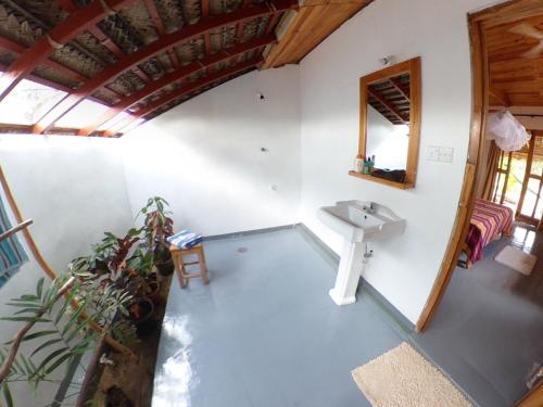 an attic bathroom with a sink and a mirror at Kadjan villa in Arugam Bay
