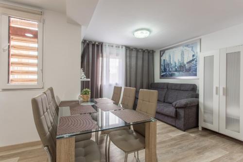 a dining room with a table and chairs and a couch at Versus Apartment near City of Arts 2 in Valencia