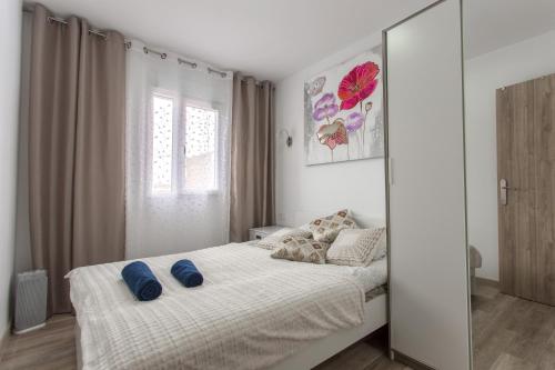 a bedroom with a bed with blue pillows on it at Versus Apartment near City of Arts 2 in Valencia