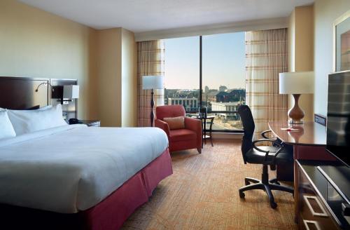 a hotel room with a bed and a desk and a chair at Marriott Bloomington Normal Hotel and Conference Center in Bloomington