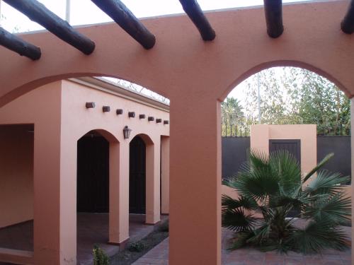 a building with two arches and a palm tree at Duplex Paraíso in Villa Nueva