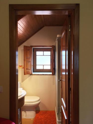 a bathroom with a toilet and a window at Casa de São Sebastião in Manteigas